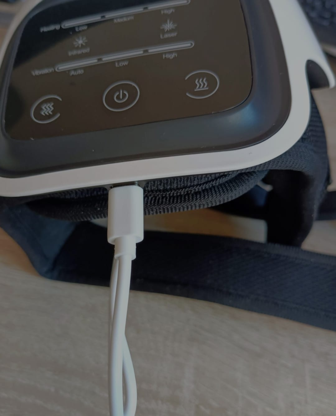 Real close-up of the charging cable connected to the knee massager